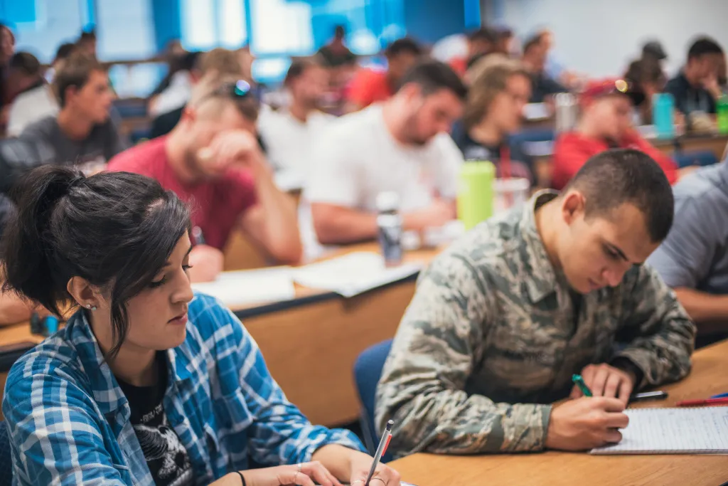 students writing in their notebooks during class