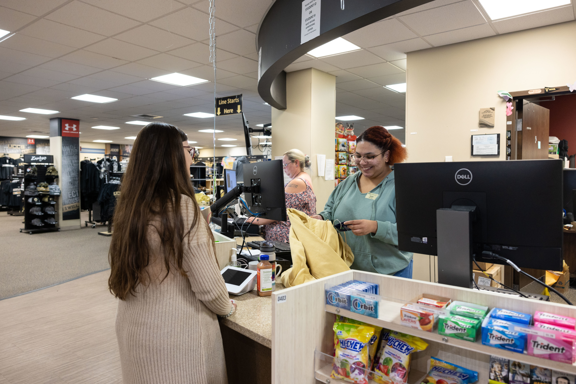 a student employee checking out a customer in the UCCS bookstore